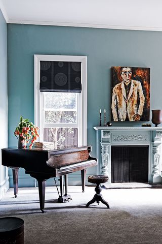 Blue living room with grand piano and fireplace