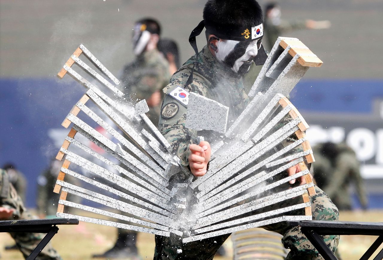 A taekwondo master breaks a row of concrete planks.