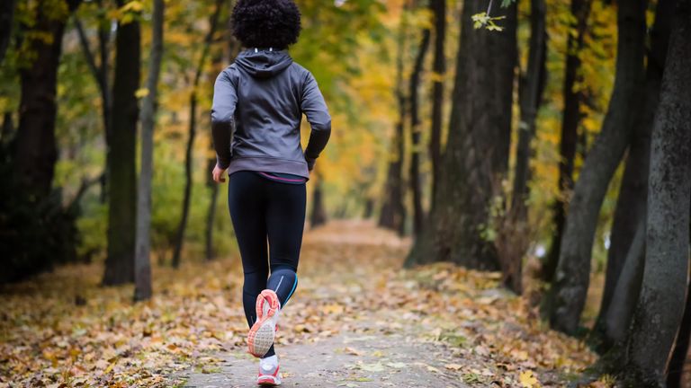A woman running outdoors in fall