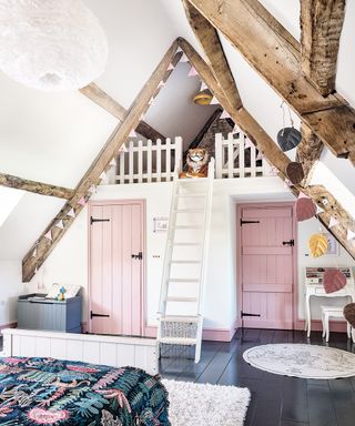 child's bedroom with beamed ceiling and pink doors in 12th century Cotswolds country house