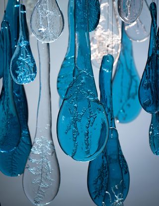 Suspended cluster of blue glass chandelier pieces, with glass etched like plant fronds