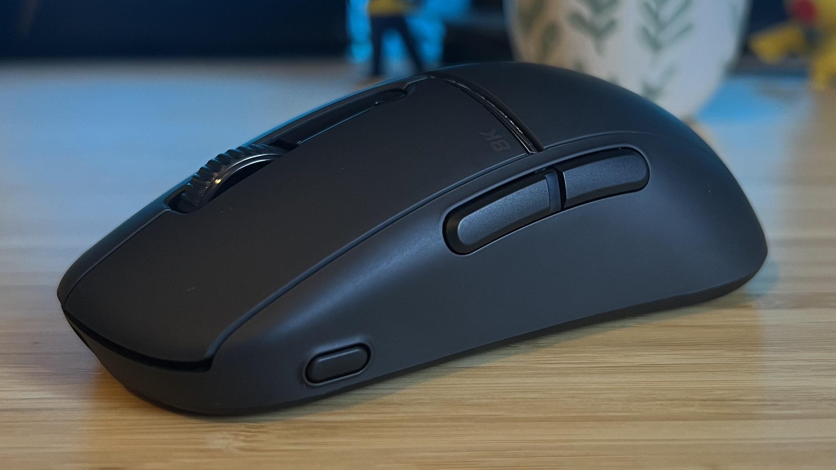 Side of Turtle Beach Burst 2 Pro gaming mouse showing buttons and DPI shifter on a wooden desk