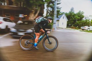 A female cyclist riding the Mondraker Arid wearing a backpack