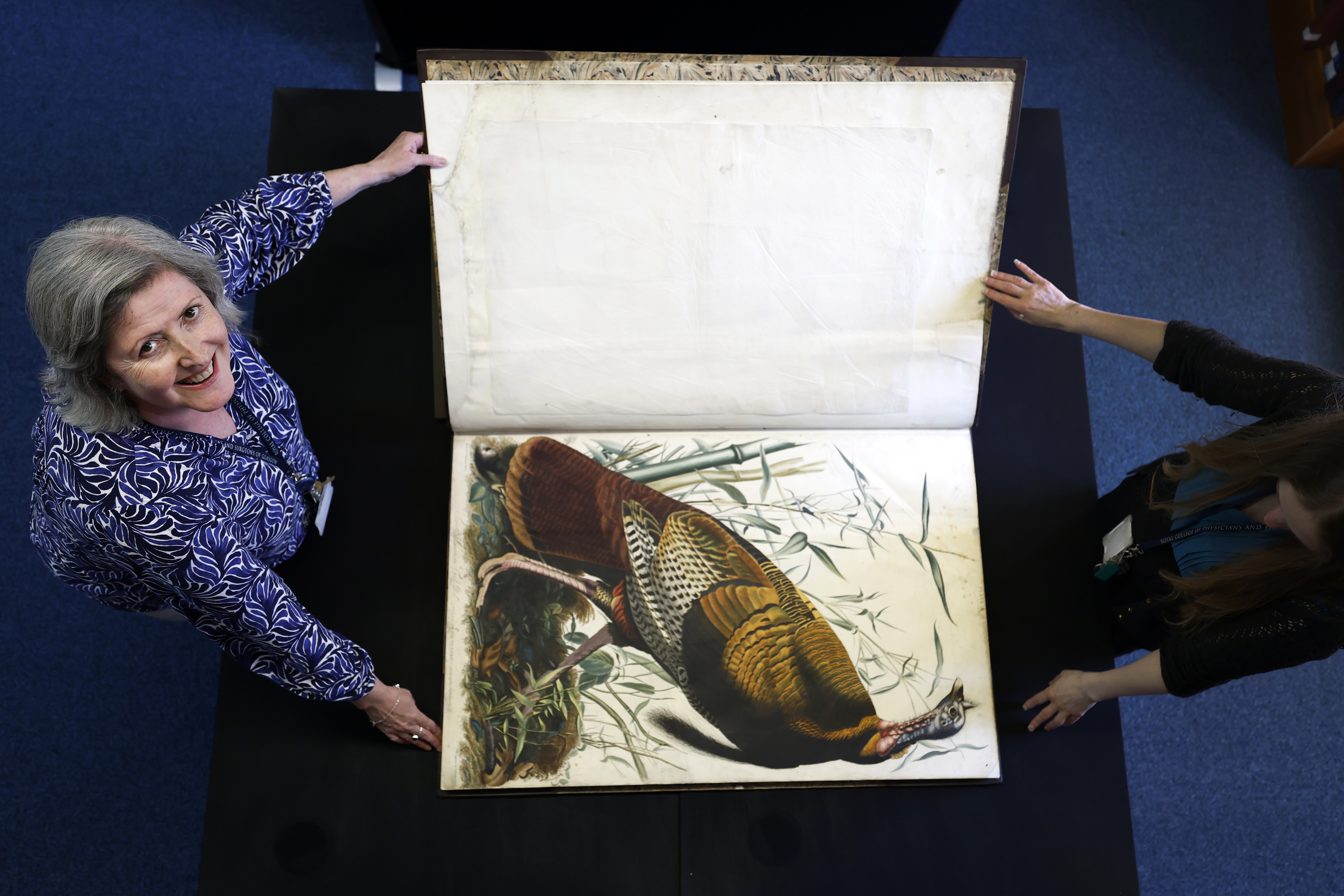  Claire McDade, Heritage Lead stands with the the book Birds of America by John James Audubon on April 30, 2026 in Glasgow, Scotland.