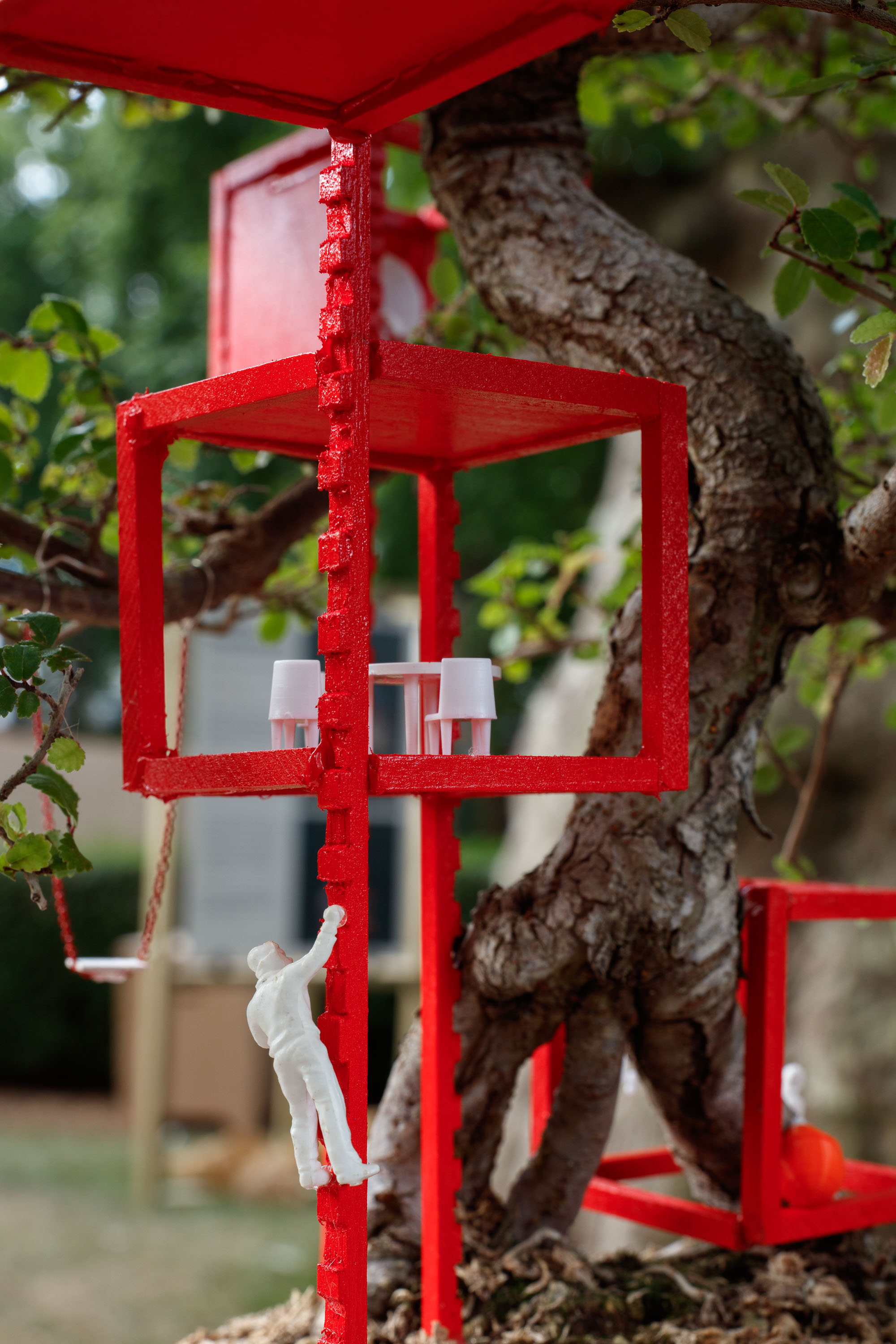 view of miniature houses in a park as part of an open air Bonsai treehouse exhibition in London