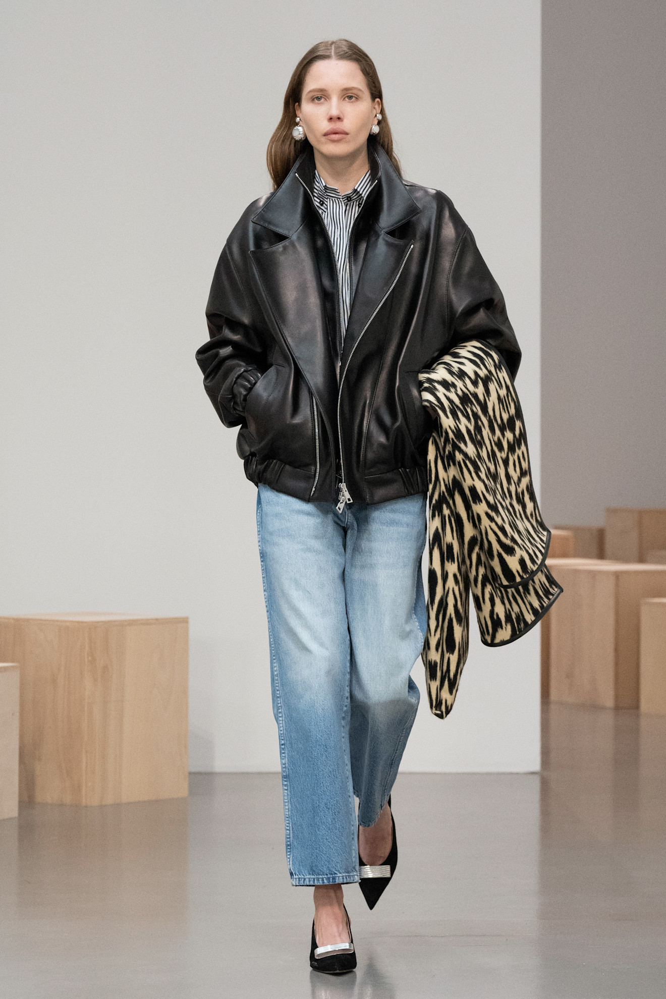 Woman in straight-leg jeans and leather jacket on the Brandon Maxwell runway.
