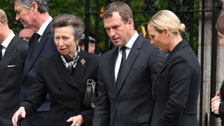 Anne, Princess Royal, Peter Phillips and Zara Phillips view the flowers left by mourners outside Balmoral Castle