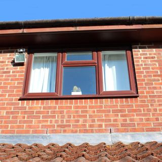 Brown uPVC window on a brick house