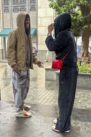 A photo of Rihanna and A$AP Rocky wearing hoodies in the rain