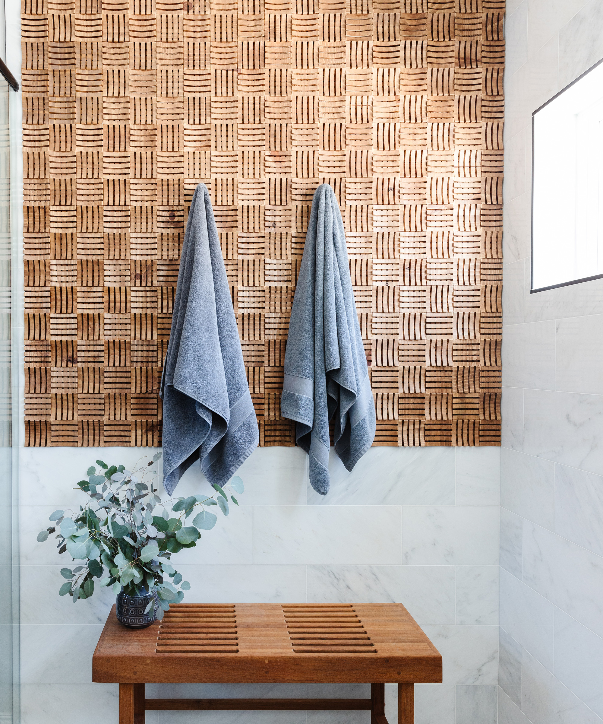 Spa style bathroom with tactile wood panel design on wall.