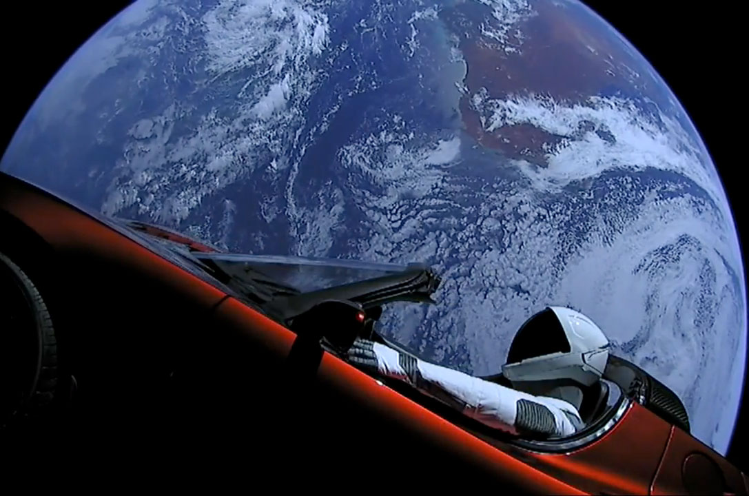 SpaceX's Starman mannequin sits inside Elon Musk's red Tesla Roadster with Earth in the background, shortly after the initial launch of SpaceX’s Falcon Heavy rocket on Feb. 6, 2018.