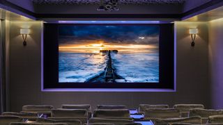 Samsung's The Wall micro-LED TV in a dark home theater with plush purple seats