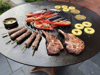 food cooking on a round flat grill outdoors