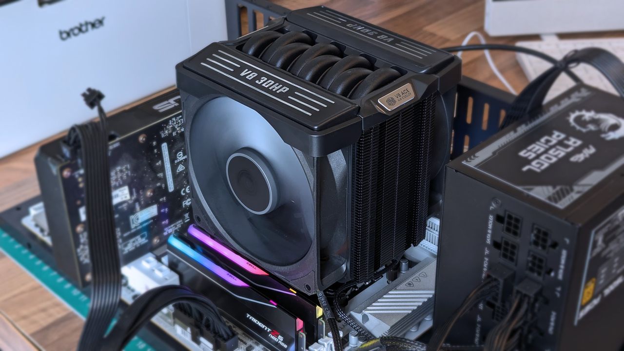 Cooler Master V8 ACE 3DHP CPU cooler installed inside a test bench with running fans above RGB RAM