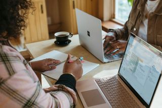 Stock photographs of people smiling and looking at laptops in a small business environment.