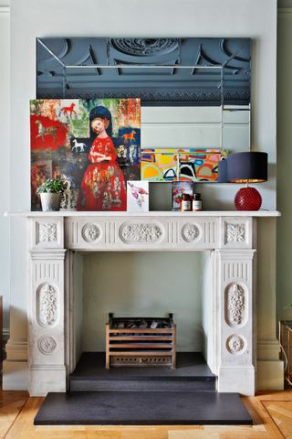 Mantel decor with large mirror above a marble fireplace
