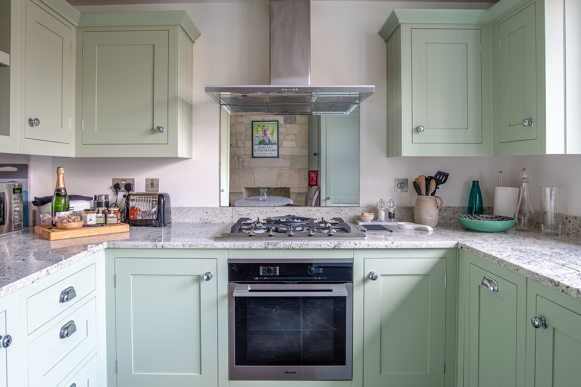 Square-on image of a light green kitchen