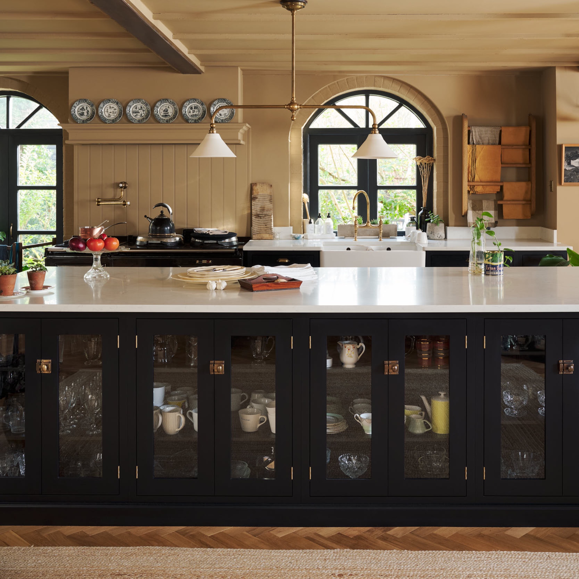 black and ochre kitchen with large kitchen island with incorporated storage, white worktops, kitchen island lighting