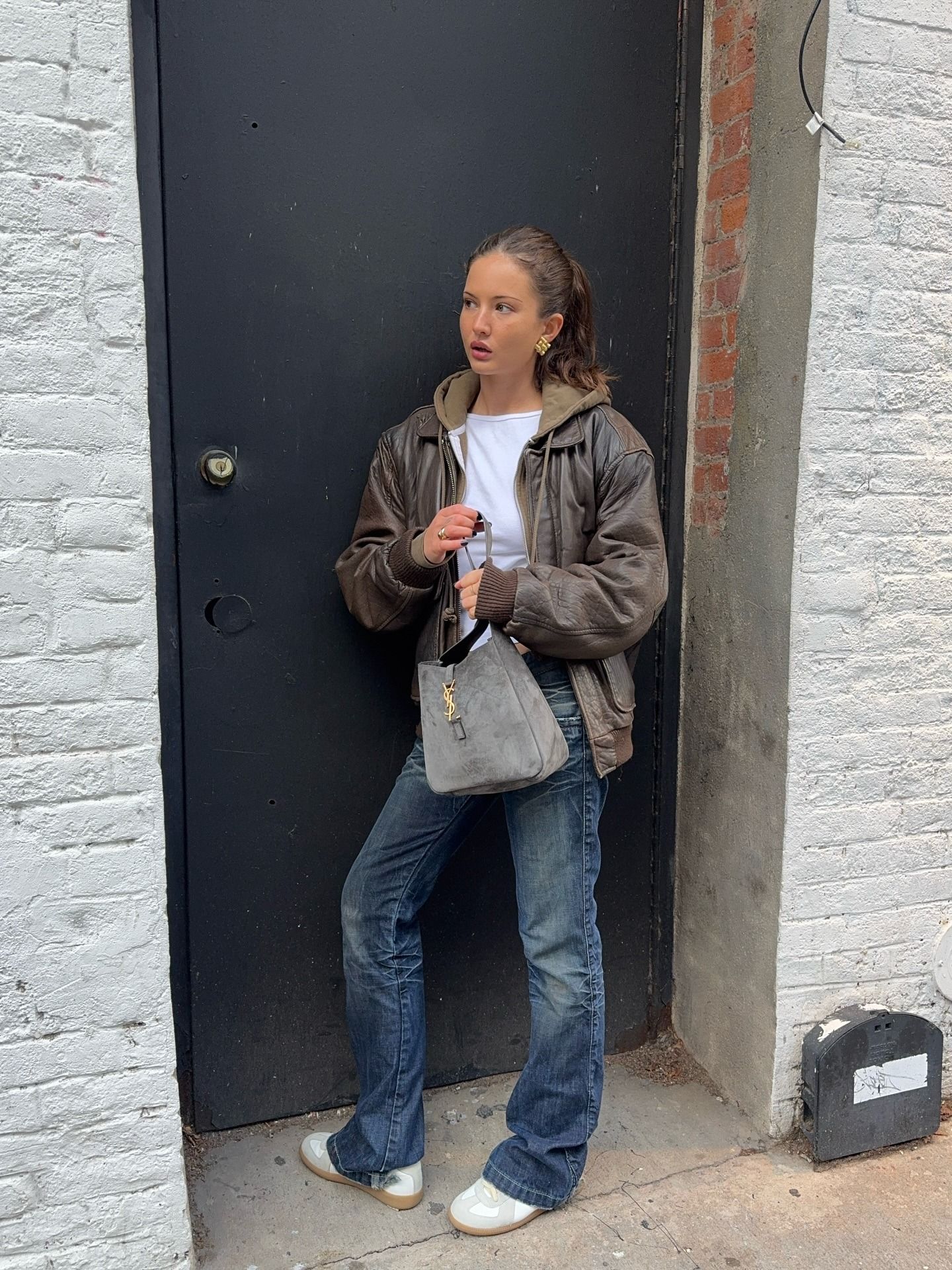 @rubylyn_ wears a white tee, hoodie, leather jacket, sneakers, and bootcut jeans.