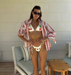 Sara Walker in a beaded crochet bikini and pink white and red linen shirt 