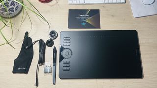 A photo of the Huion HS610 on a table with all its accessories