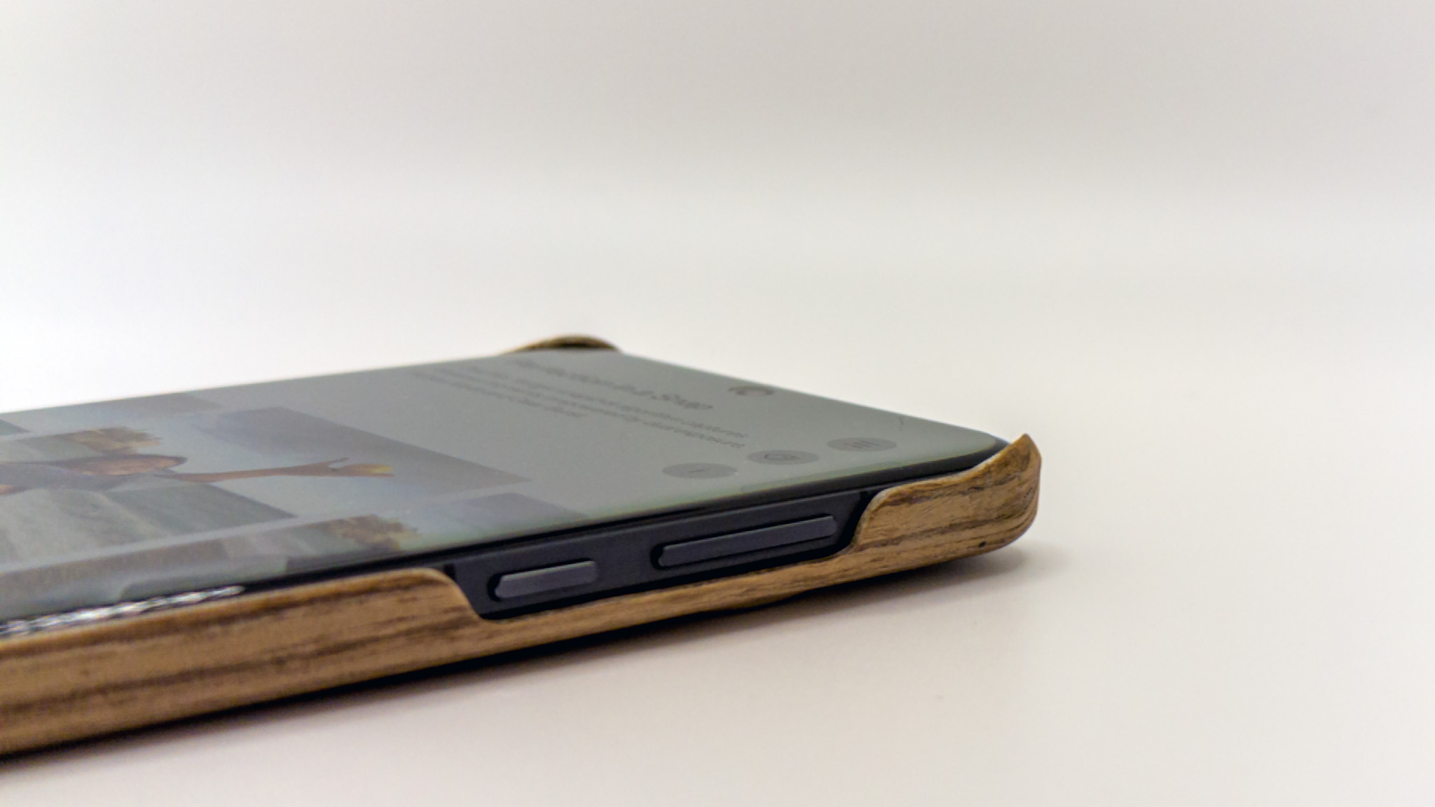 The raised corners on the official OnePlus 13 wood case