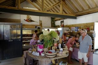 The inside of the restaurant of Clarkson's farm shop shows an ice cream stand and people queing