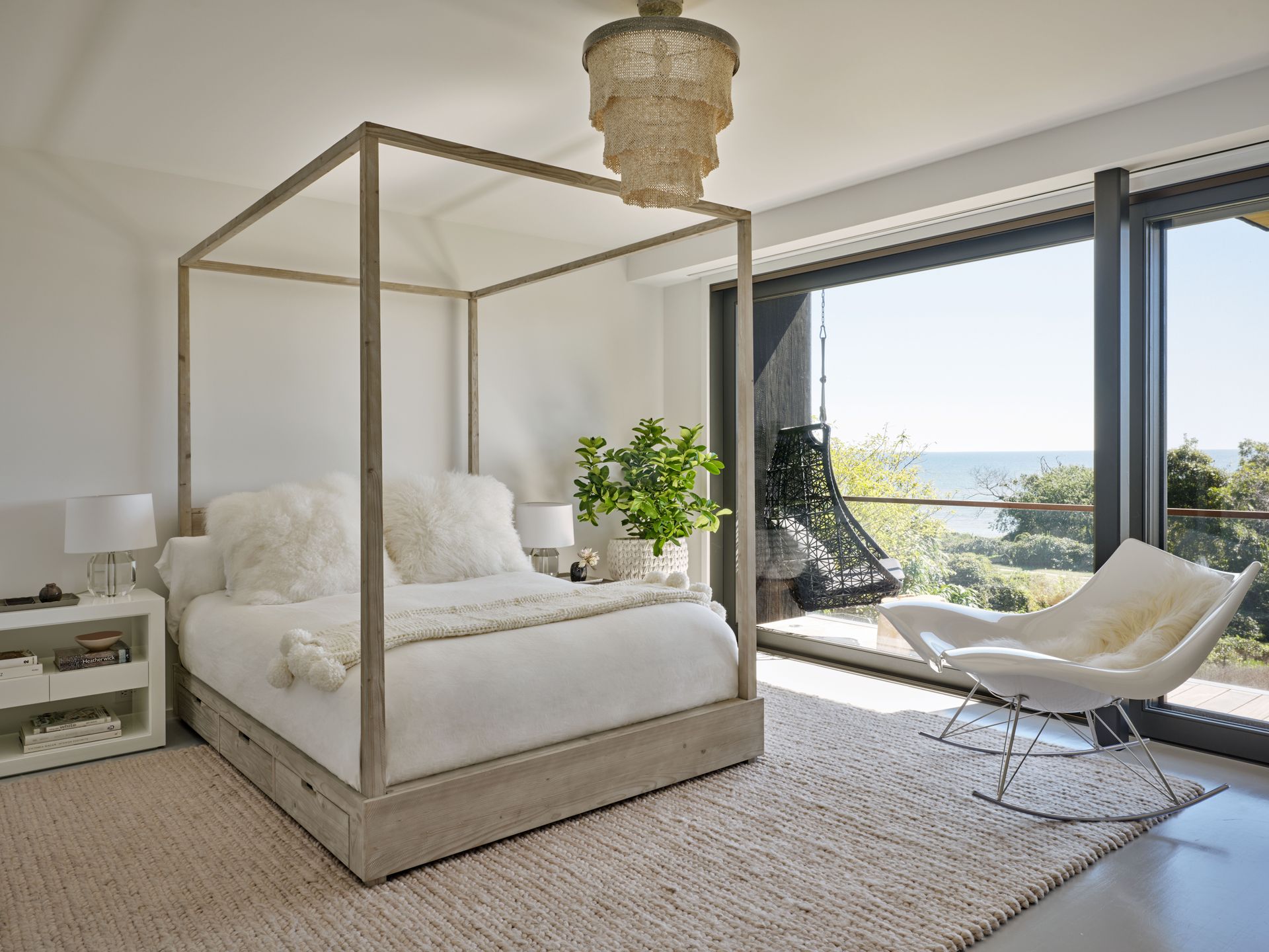 neutral bedroom with white four poster bed and ocean views