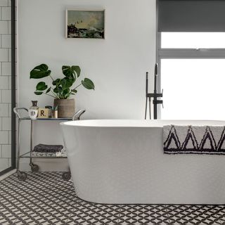 monochrome bathroom with freestanding bathtub and black taps