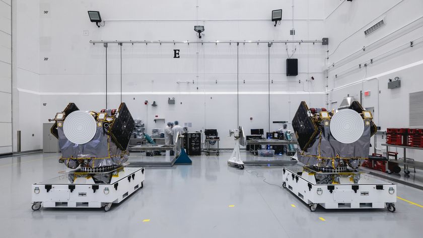 Two engines sit on white platforms in a clean warehouse