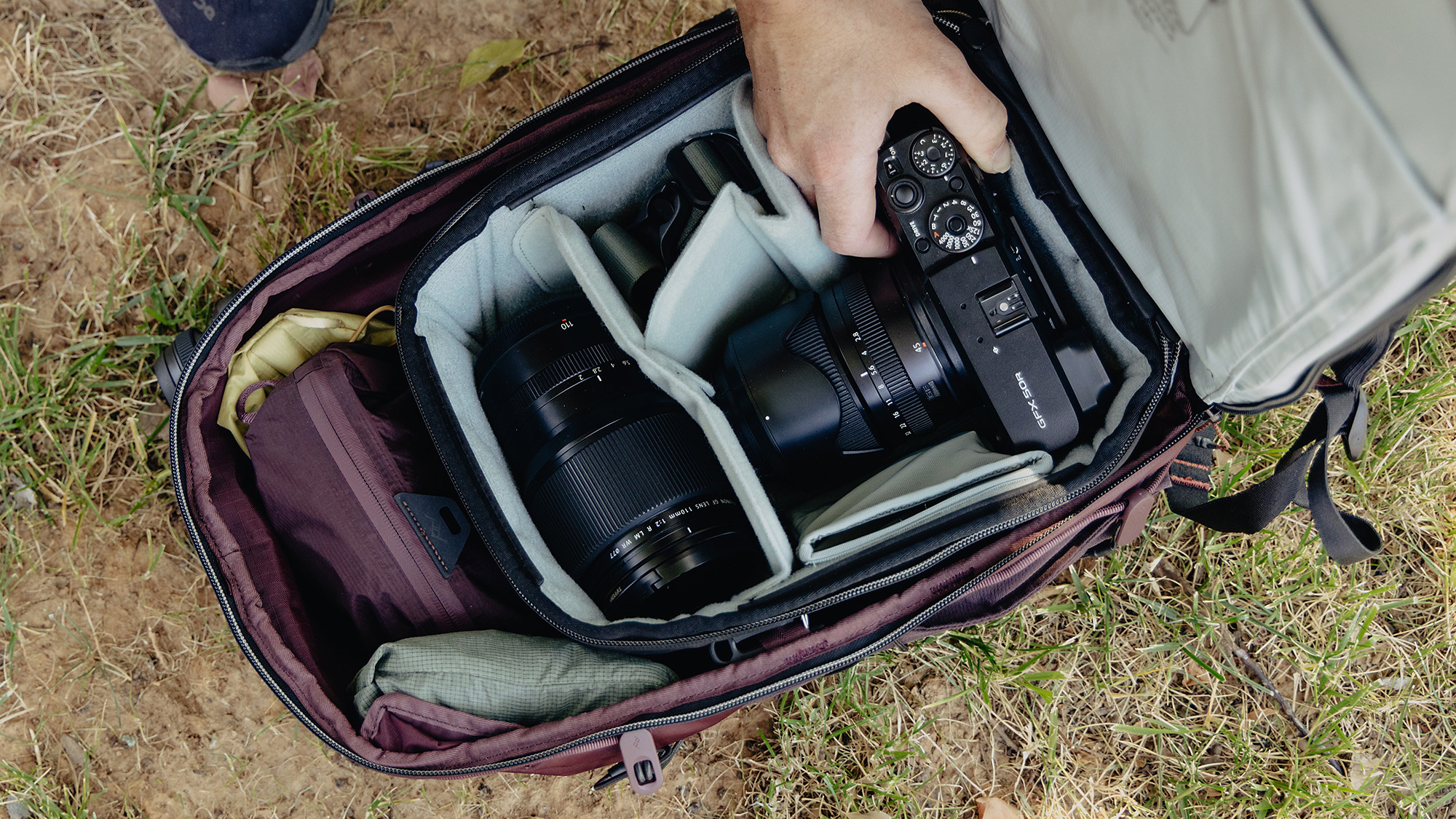 Peak Design Outdoor Backpack 18L interior with hand reaching in to retrieve camera