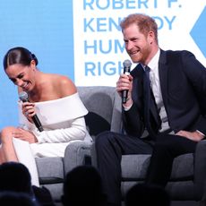Prince Harry and Meghan Markle laugh onstage