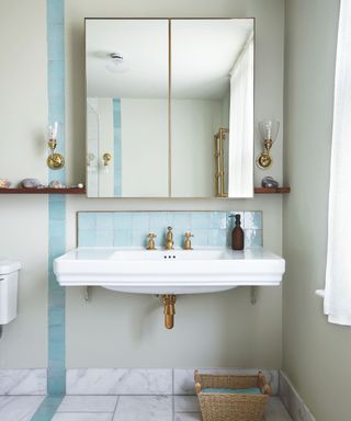 Blue and white bathroom, white sink with mirrored cabinet above