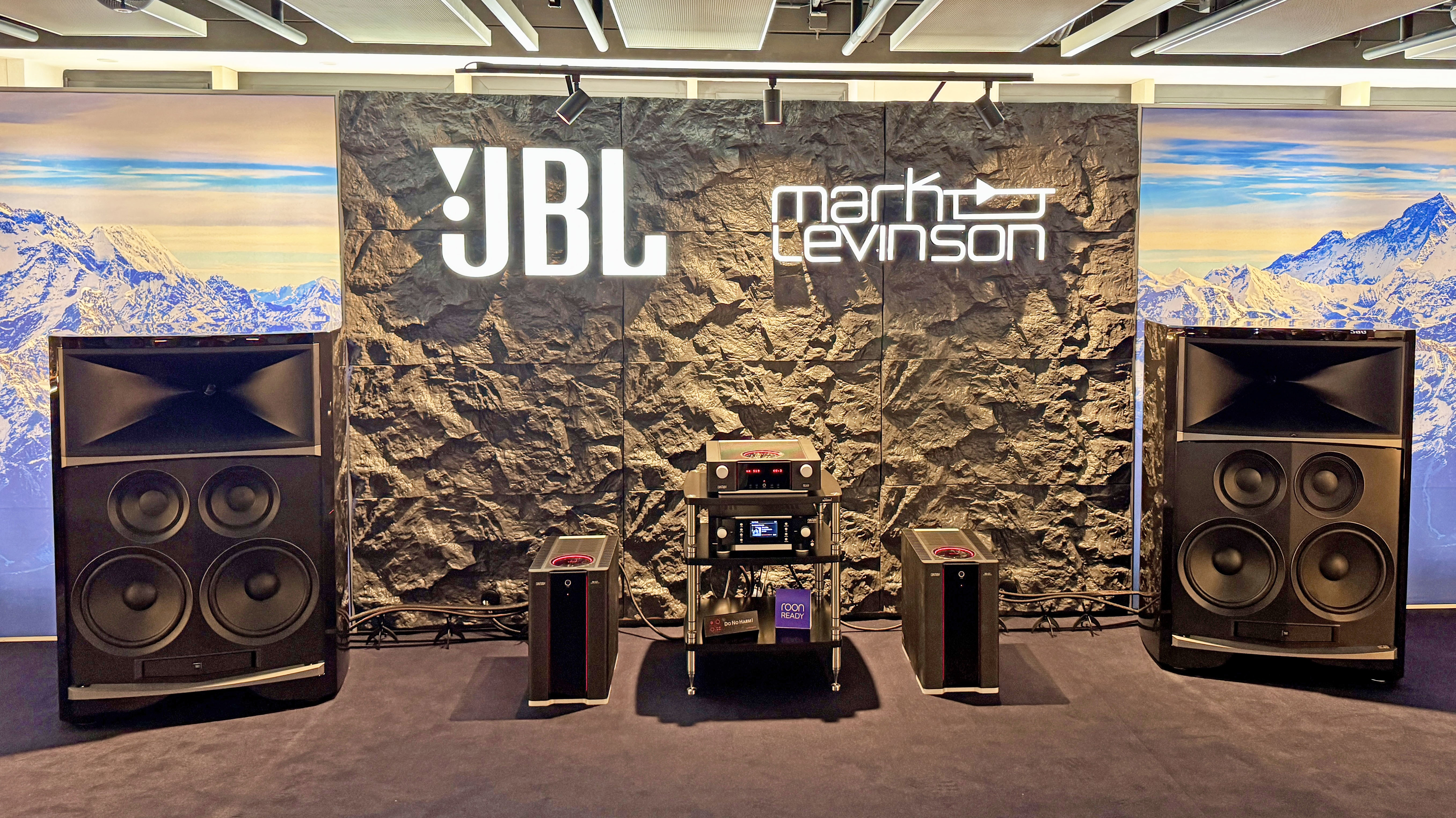 The JBL Summit Everest speakers in a large demo room, with amplifiers and players in the center