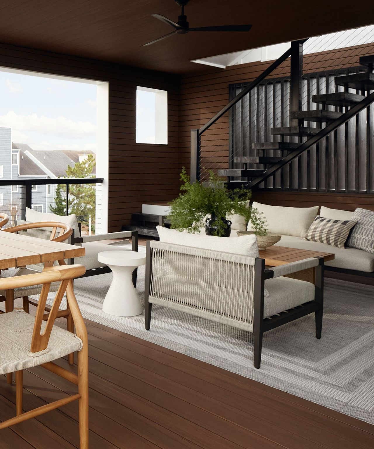 An outdoor seating area with a black staircase and an outdoor rug