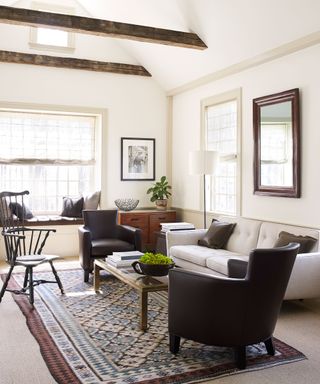 Simple cream living room with wood furniture, leather armchairs and rug