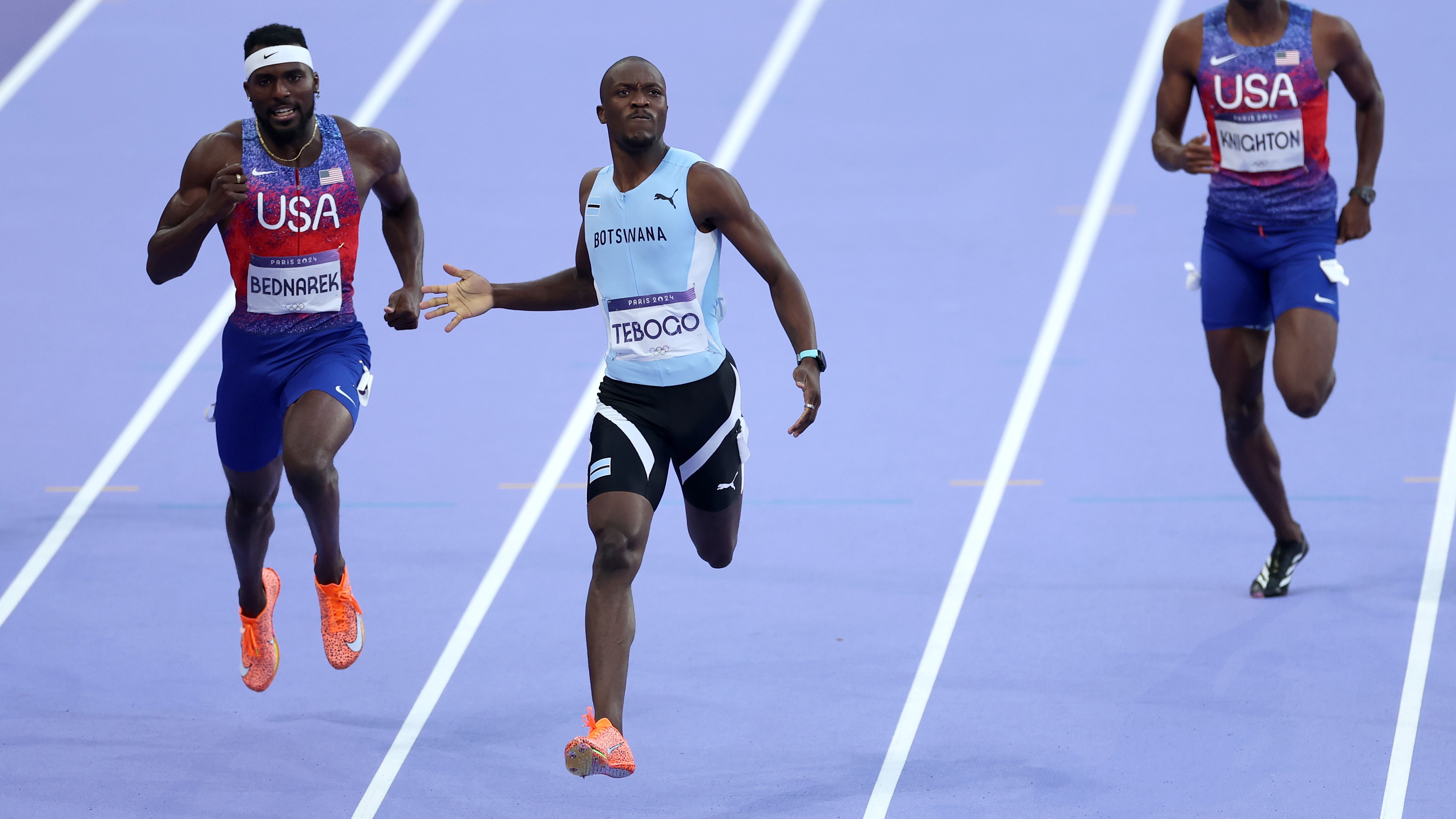 Letsile Tebogo (C) of Team Botswana crosses the finish line to win the gold medal in the Men's 200m Final on day thirteen of the Olympic Games Paris 2024 at Stade de France on August 08, 2024 in Paris, France.