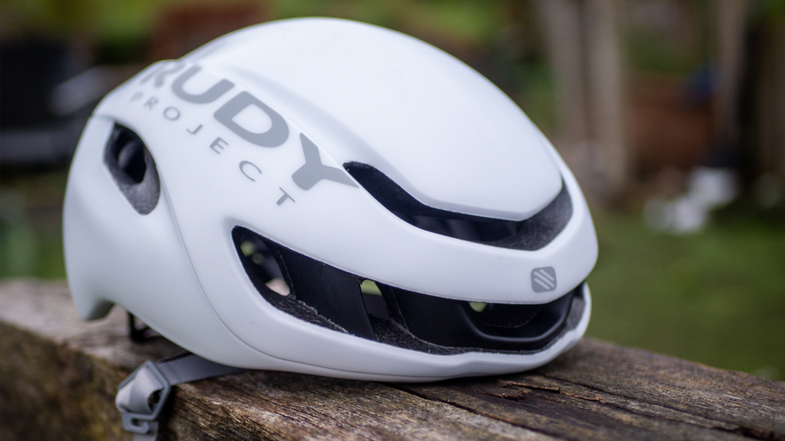 A White Rudy Project Nytron sits on a wooden bench
