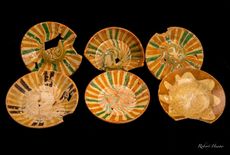 The colonial dishes are decorated with striking abstract patterns made using what is called "slip trailing." 