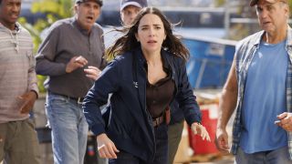 Mariel Molino's Lala running through a crowd with a panicked expression in NCIS: Origins