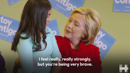 Hillary Clinton speaks to a young girl.