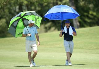 Pepperell and Wilson chat whilst holding up umbrellas
