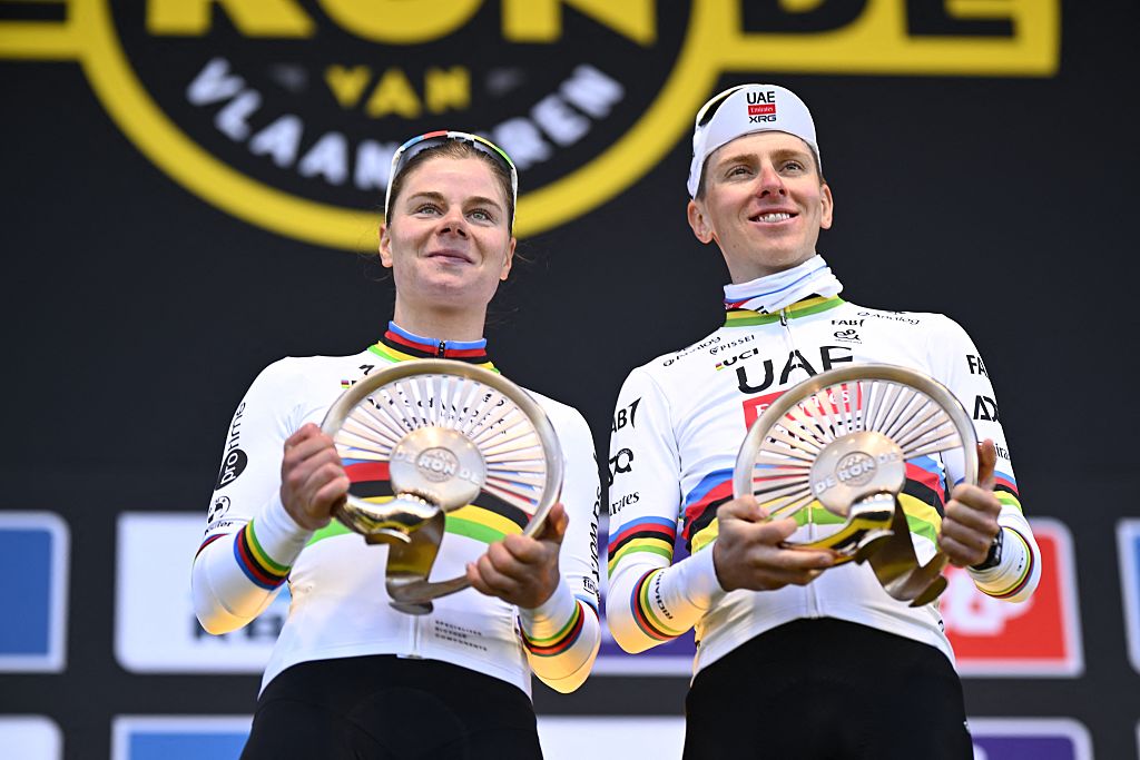 World champions Lotte Kopecky and Tadej Pogacar hold their Tour of Flanders trophies on the podium together 