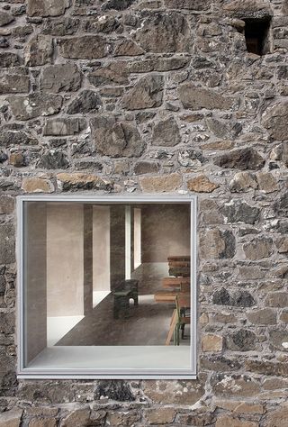 outside the stone walls looking in at the community dining hall, Croft 3 by London based studio fardaa