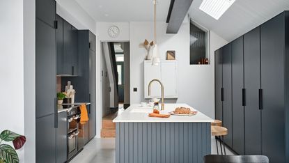 Extended kitchen with dark grey units, white worktop and rooflights