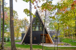rear facade among the leafy surrounds of Lake Placid A-Frame by Strand Design
