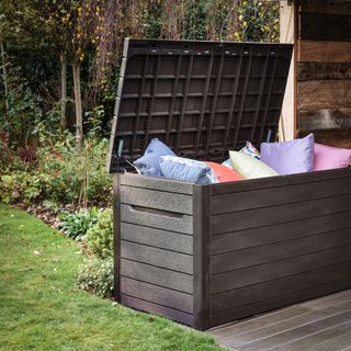 outdoor cushion storage trunk in garden, cushions showing on top