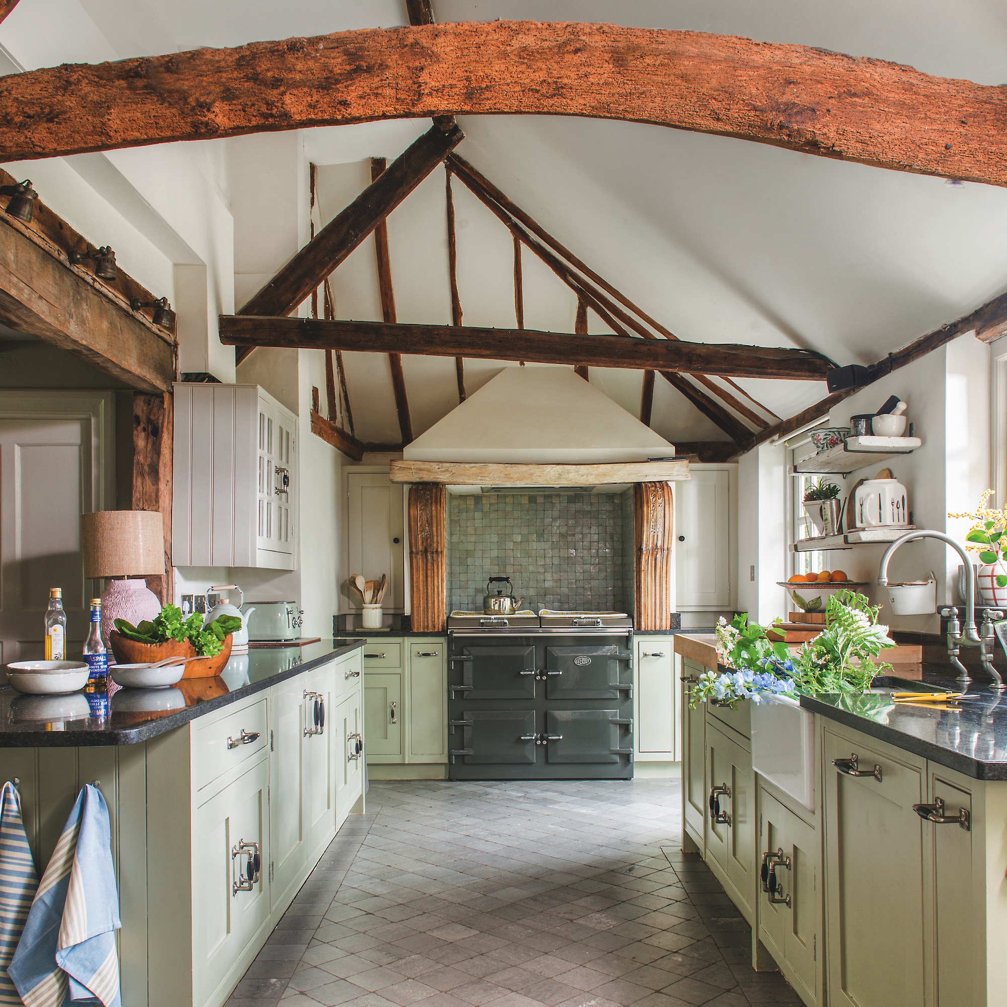 kitchen with beamed ceiling and wooden cabinetry painted pale green with Everhot stove