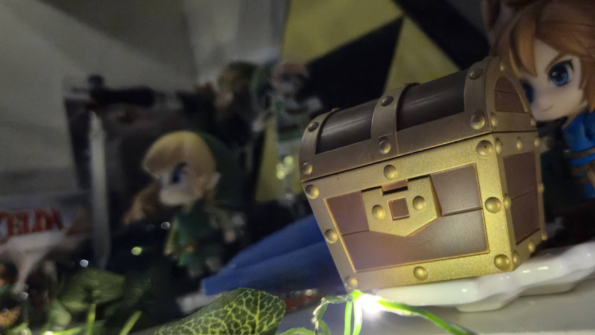 Photo of a treasure chest from Zelda sitting on a shelf infront of other collectibles.