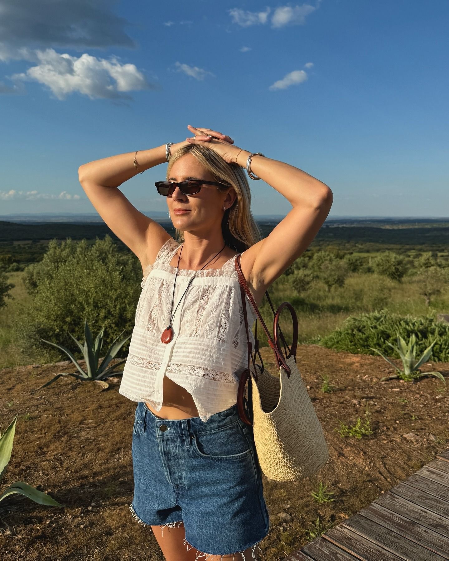 Influencer wearing a white top and denim shorts